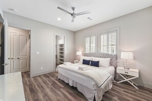A bedroom with a bed, nightstands, a ceiling fan, and a window with blinds. - Relax and enjoy at Alamo Sea! Two king suites! (Galveston)