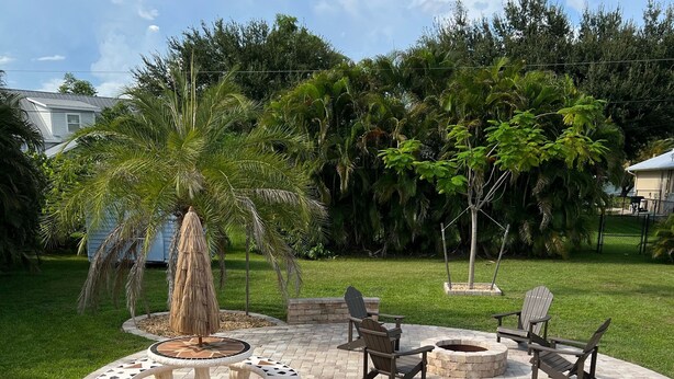A patio area with a fire pit, outdoor furniture, and potted plants.