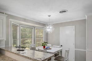 A kitchen with a marble countertop, white cabinetry, and a chandelier. - Cheerful, Relaxing Home Away From Home! (Jackson)
