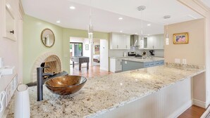 A modern kitchen with a large island, white cabinets, and a pendant light. - Beautiful Carmel House
 (Carmel)
