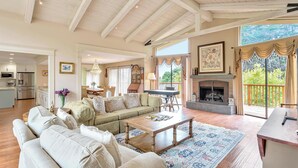 A spacious living room with a high ceiling, a fireplace, and a view of the outdoors. - Beautiful Carmel House
 (Carmel)
