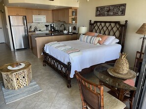 A bedroom with a bed, bedside table, and a small wooden stool.