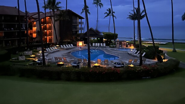 Ein Resort mit Pool, Palmen und einem Gebäude mit Balkonen.