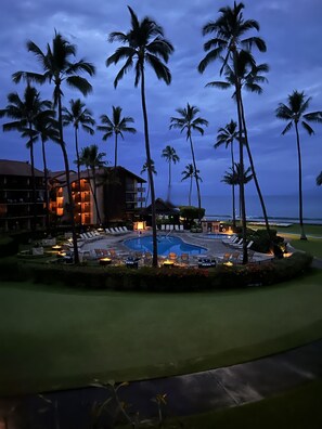 Ein Resort mit Pool, Palmen und einem Gebäude mit Balkonen.