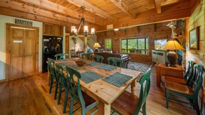 L’intérieur d’un chalet en bois comprend un coin repas, une cuisine et offre une vue sur l’extérieur.
