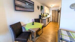 Un appartement moderne comprenant un coin repas, une kitchenette et un espace de vie.