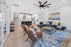Uma sala de estar moderna com sofá, mesa de centro e área de jantar com cadeiras.