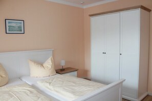 Et soveværelse med seng, natbord og garderobe.