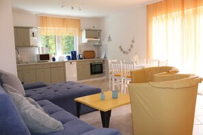Et moderne køkken med spiseplads, sofa og bord.