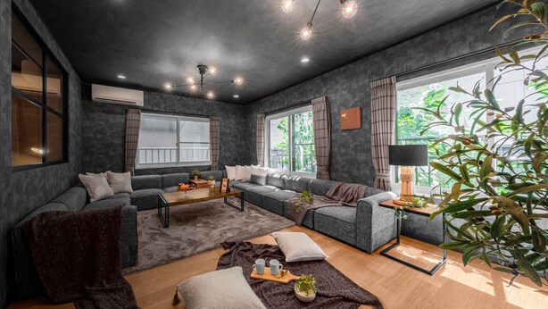 Una sala moderna con un sofá gris, una mesa de centro de madera y un amplio ventanal con cortinas.