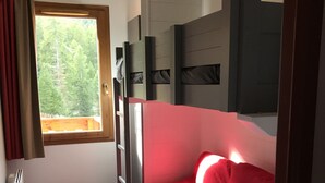 A small, compact bedroom with a bed, a small table, and a window. - Residence on the slopes with heated outdoor pool (Vars)