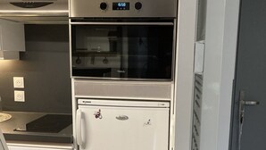 A compact kitchen with a built-in oven, microwave, and refrigerator. - Residence on the slopes with heated outdoor pool (Vars)