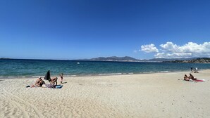 Une plage où des gens se prélassent au soleil et se baignent.