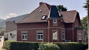 Un edifici gran de totxins vermells amb un teulat pronunciat, nombroses finestres i un altrer ben cuidat a la façana.
