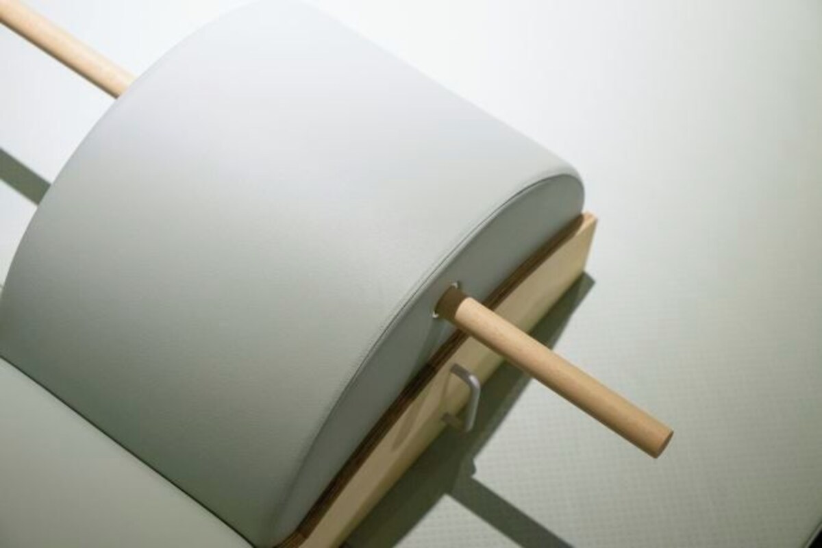 A cylindrical object with a wooden handle, possibly a piece of furniture or equipment.