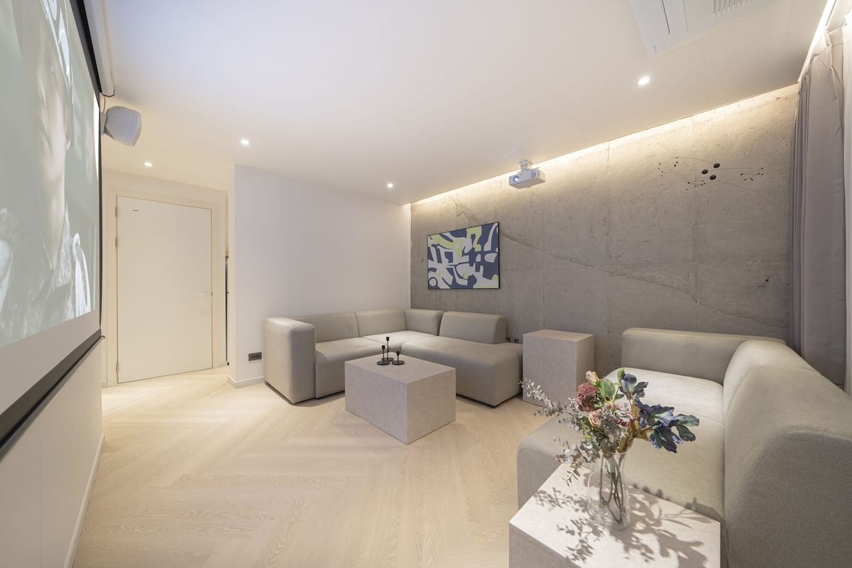 A modern living room with a sectional sofa, a coffee table, and a decorative vase.