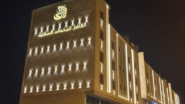 A modern hotel with a prominent logo and Arabic script on the facade. - Alfadel Residential Units (Al Baha)