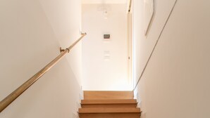 A wooden staircase with white walls and a handrail on the left. - Biennale Gallery Suite (Venezia)