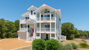 A two-story house with a balcony, a garage, and a well-maintained lawn. - Landon Sea: Private Pool, Hot Tub, Dog-Friendly (Corolla)