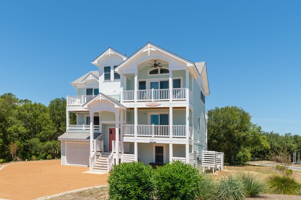 A multi-story beachfront house with a covered porch, a garage, and a swimming pool. - Landon Sea: Private Pool, Hot Tub, Dog-Friendly (Corolla)