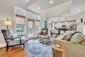 Relax in this inviting living space with a comfortable seating area, wooden coffee table, and modern kitchen.