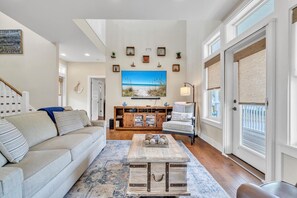 Relax in this stylish living room with a sofa, coffee table, and entertainment center.
