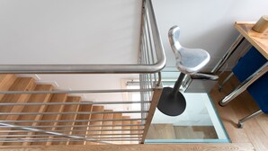 Eine moderne Treppe mit Glasboden, Metallgeländern und Holzverkleidung.