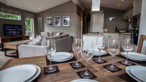 A modern living room with a dining area set for six. - Maple Lodge | sleeps 6 - Hot Tub, Dog Friendly - 5* Visit England (Pickering)