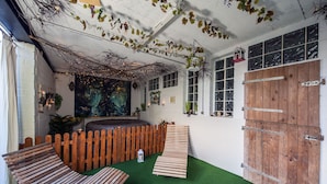 Une pièce chaleureuse avec un banc en bois, une petite table et une clôture décorative.