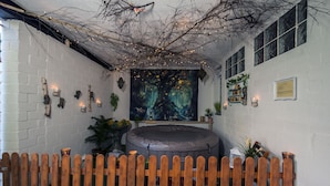Une pièce chaleureuse avec un espace salon circulaire, une fresque murale et une clôture en bois.
