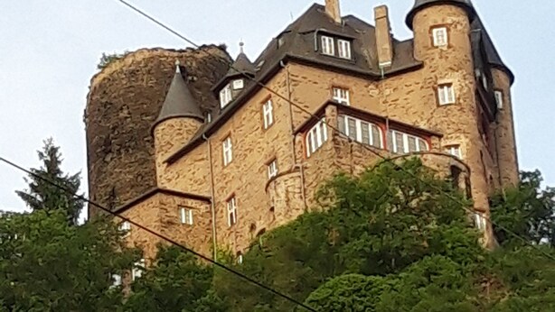 Un bâtiment qui ressemble à un château, avec de nombreuses tours et un grand mur de pierre.