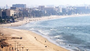 A beach with a sandy shore, a few people, and buildings in the background. - Hotel Naaz Executive Near T2 Airport (Mumbai)