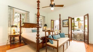 A bedroom with a four-poster bed, a wooden chair, a small table, and a ceiling fan. - The Gideon Lowe House - Old Town Key West  (Key West)