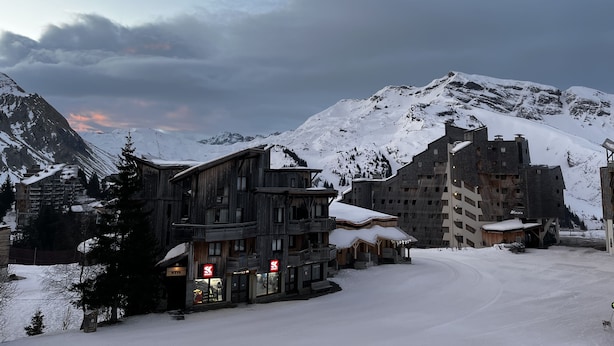 A snow-covered mountain town with wooden buildings and a ski resort.