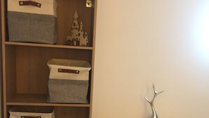 A wooden shelving unit with storage bins and a decorative vase.