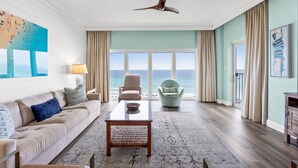 A spacious living room with a large window, a ceiling fan, a sofa, a coffee table, and a chair.