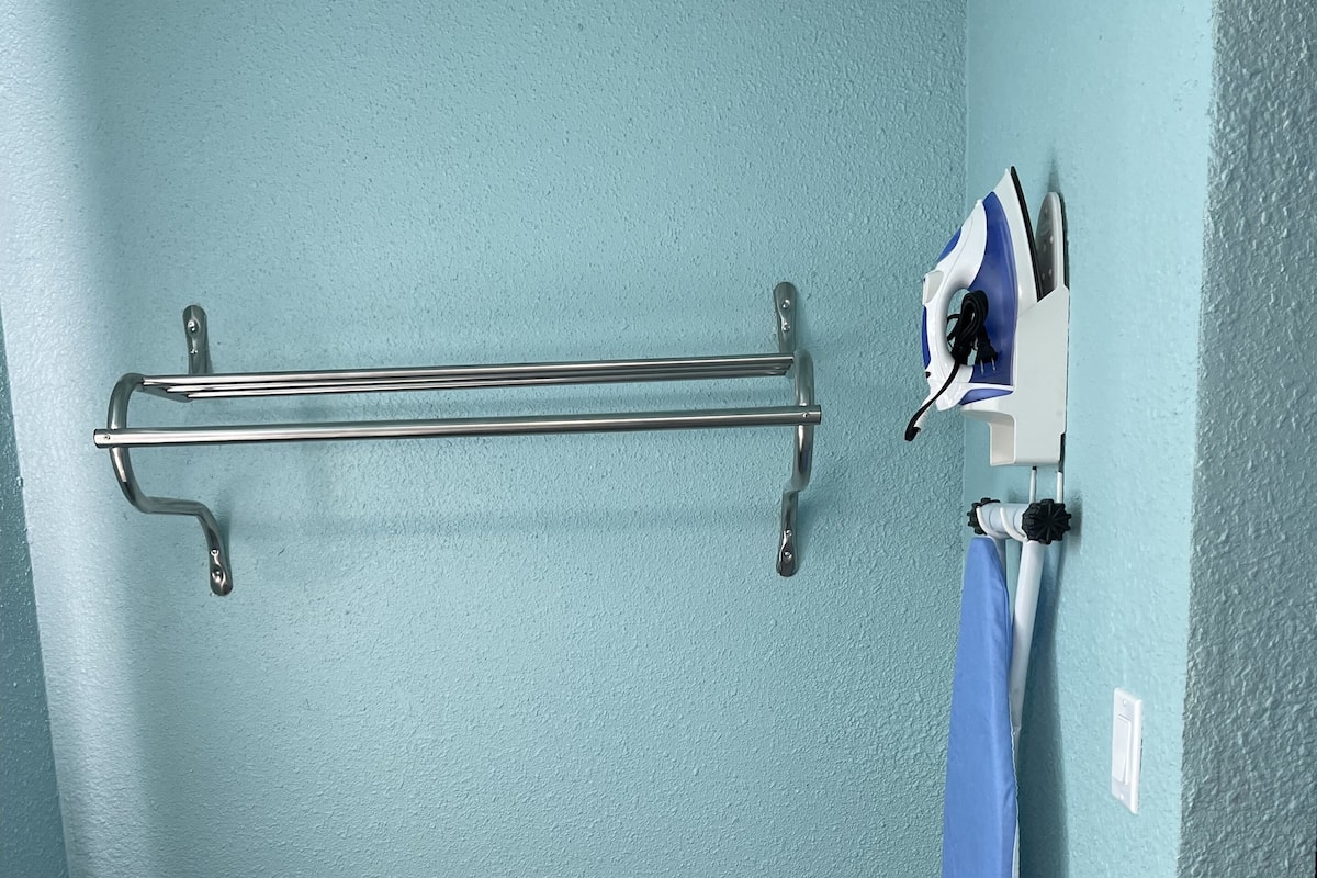 A bathroom with a towel rack, a shower curtain, and a toilet.