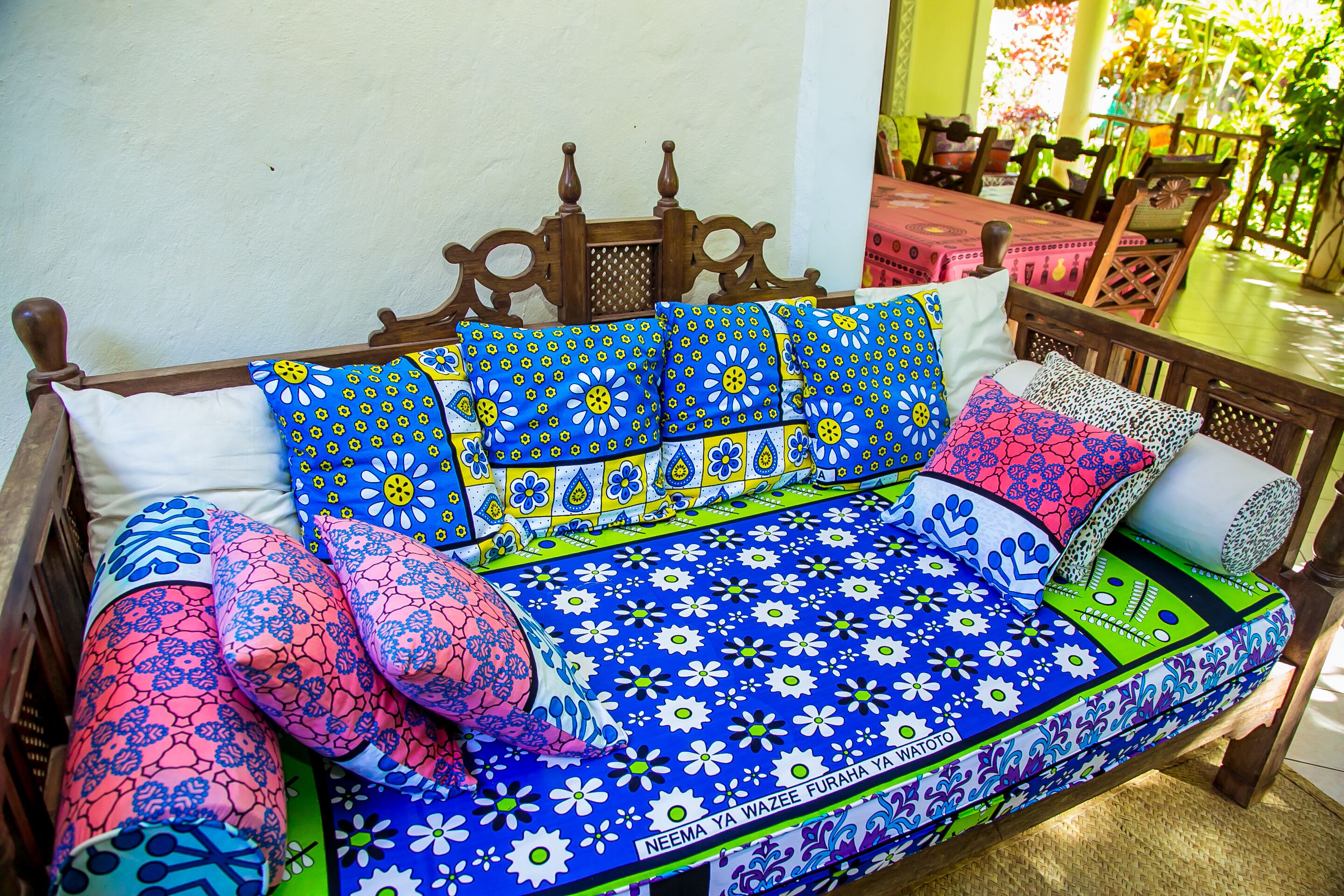A bed with a floral-patterned bedspread and multiple pillows.
