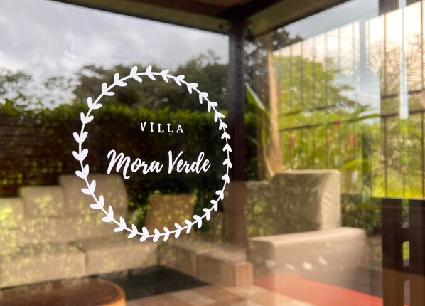 A villa named 'Villa Mora Verde' with a view of outdoor seating and greenery.