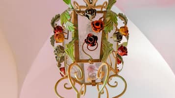 A decorative metal wall piece with floral and leaf motifs.