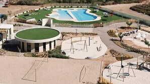 Een resort met een groot zwembad, een zandstrand en uitzicht op de oceaan.