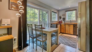 Una cocina moderna con una mesa de comedor, sillas y un refrigerador.