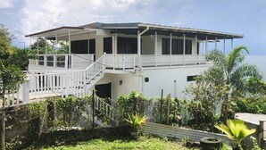 A two-story house with a covered porch and a staircase leading to the upper floor.