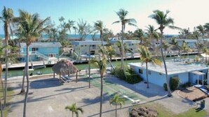A resort with multiple buildings, a pool area, and palm trees. - Beautiful Ocean Access Islamorada Condo. MM 76.5 Bring your Boat (Islamorada)