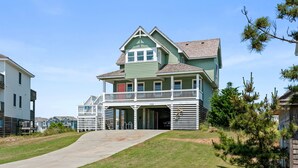 A two-story house with a balcony and a garage. - Welcome to MAJESTY! Ocean Views-Hot Tub-Pool Access (Nags Head)