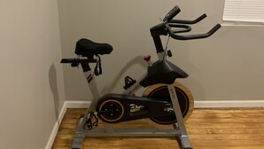 A stationary exercise bike in a room with wooden flooring and light gray walls. - Perfect Location Just 0.5 Miles from Notre Dame’s Campus! (South Bend)