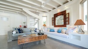 A spacious living room with a white sofa, a wooden coffee table, and a large mirror above a white console table. - AVRAMAR VILLA PLAYA LAS BALLENAS LAS TERRENAS (Las Terrenas)
