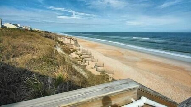 A beach with a wooden staircase leading down to the shore, a clear sky, and ocean waves. - Pet Friendly Studio with Private Fenced Yard (Jacksonville)