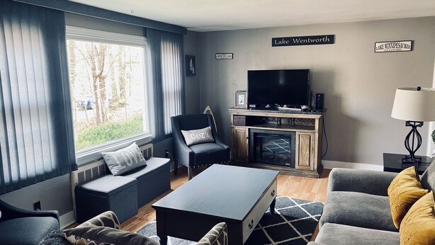 A modern living room with a fireplace, a television, and a comfortable seating area.