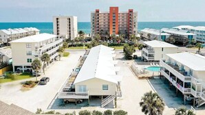 Ein Hotel direkt am Strand mit mehreren Gebäuden, einem Schwimmbad und Blick auf den Ozean.